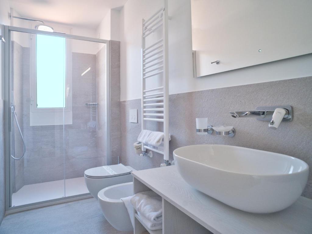 une salle de bain avec un lavabo, des toilettes et une douche dans l'établissement Hotel Medusa, à Finale Ligure