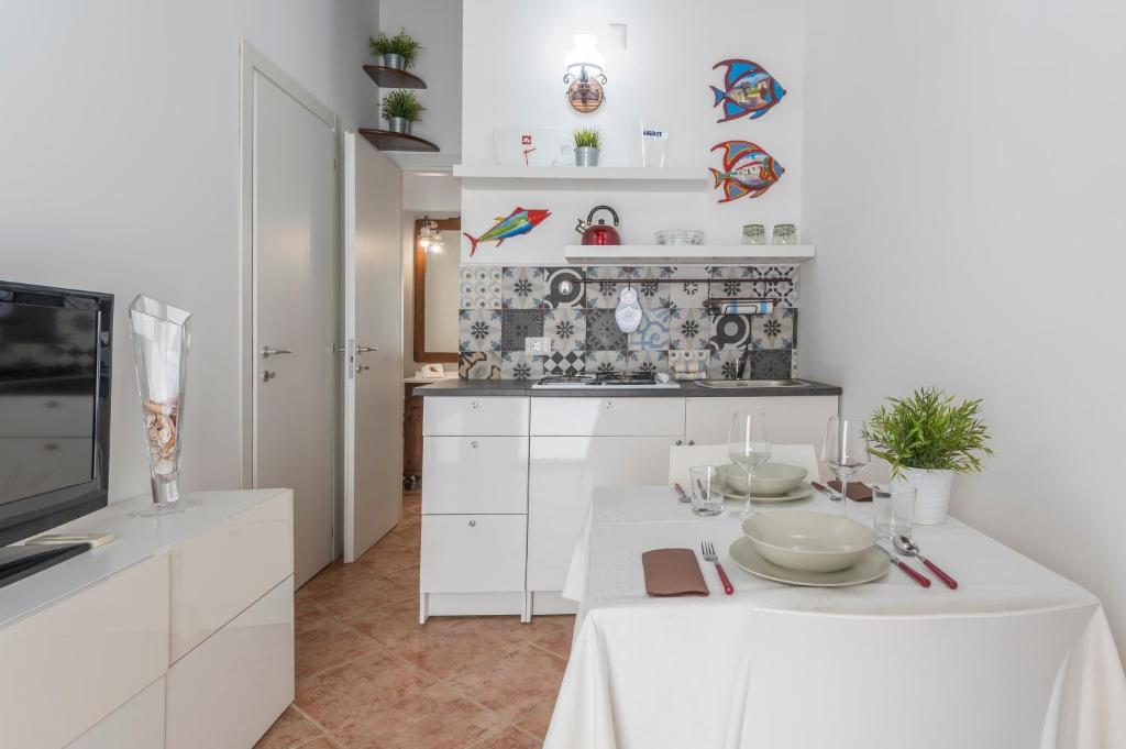 une cuisine blanche avec une table et un chiffon de table blanc dans l'établissement Koreble In Disco, à Marina di Ragusa