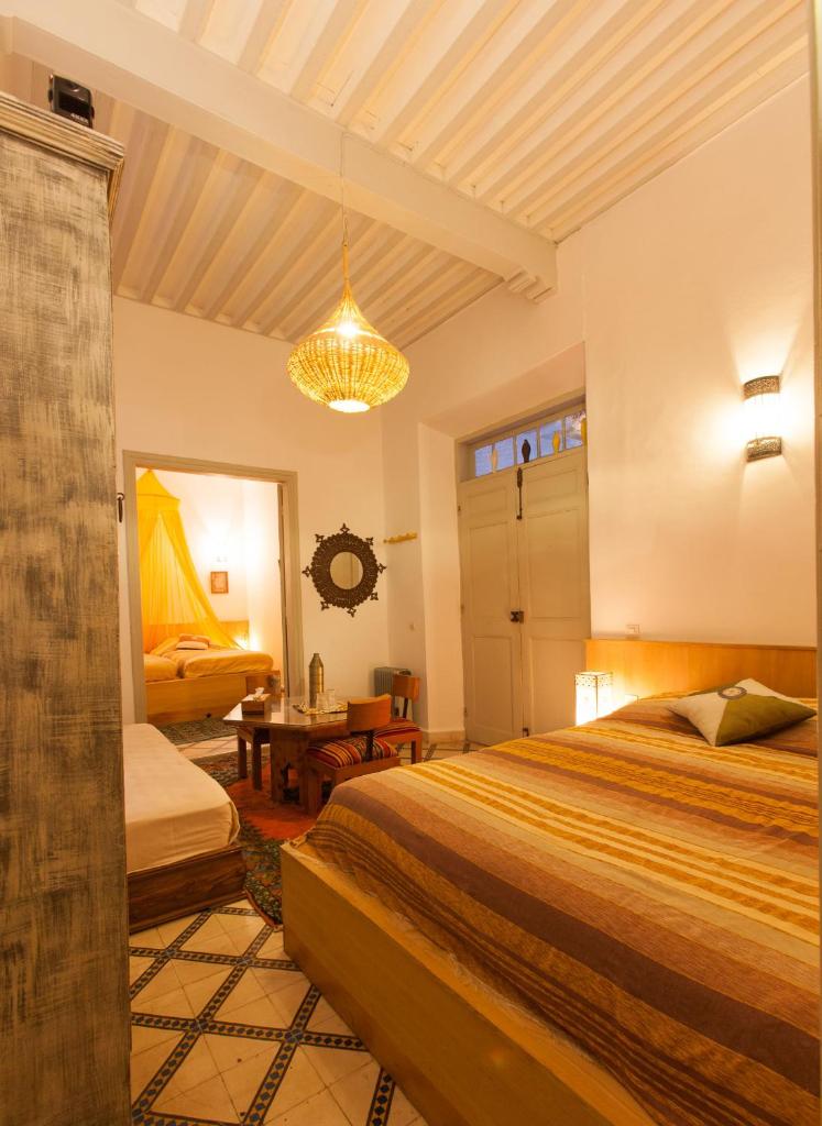 une chambre avec deux lits et un lustre dans l'établissement Riad Al Zahia, à Essaouira