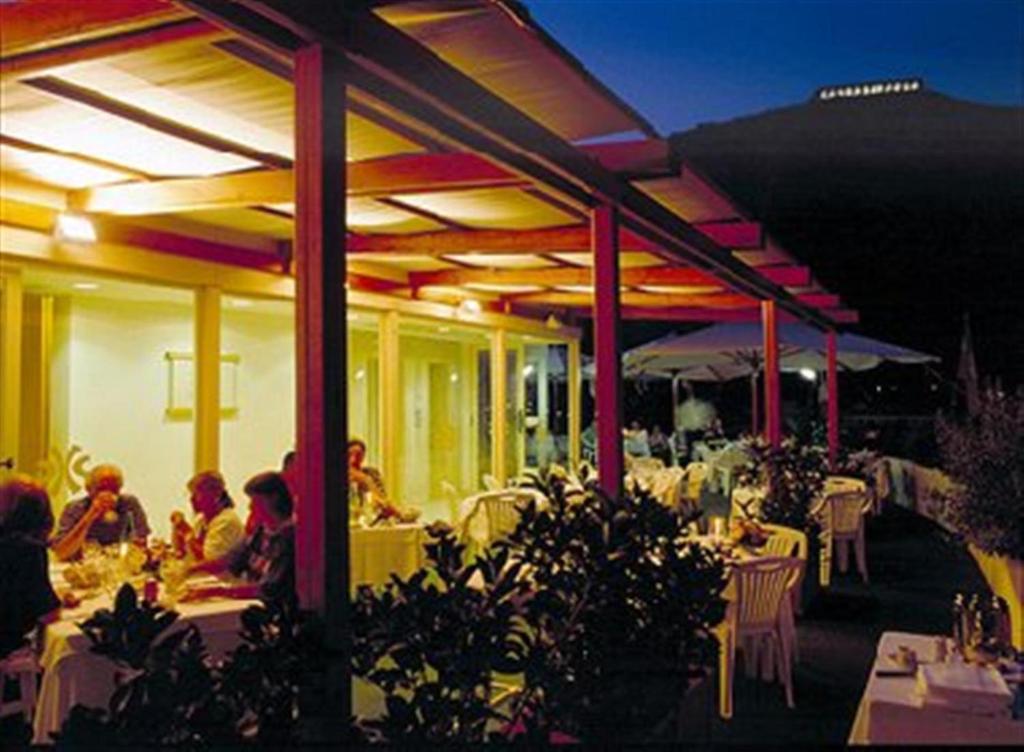 un groupe de personnes assises à des tables dans un restaurant dans l'établissement Grand Hotel Palace, à Terracine