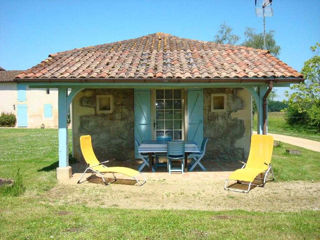 deux chaises et une table devant une maison dans l'établissement Château du Rau - Dépendance - Gîte n°12, à Gamarde-les-Bains