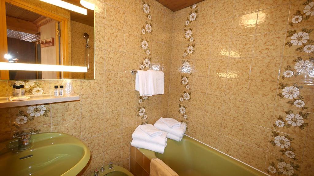 La salle de bains est pourvue d'un lavabo et d'une baignoire verte. dans l'établissement L'Annexe, à Val dʼIsère