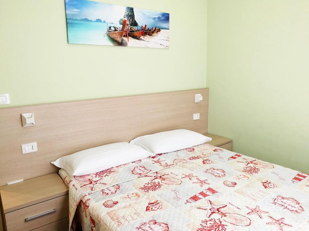 une chambre avec un lit et un tableau au mur dans l'établissement Margherita Rimini - Appartamenti al Mare, à Rimini