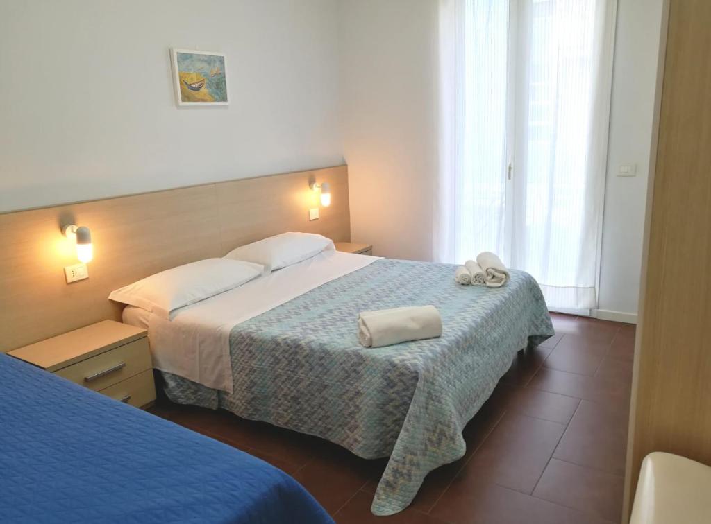 une chambre d'hôtel avec deux lits avec des serviettes dessus dans l'établissement Margherita Rimini - Appartamenti al Mare, à Rimini