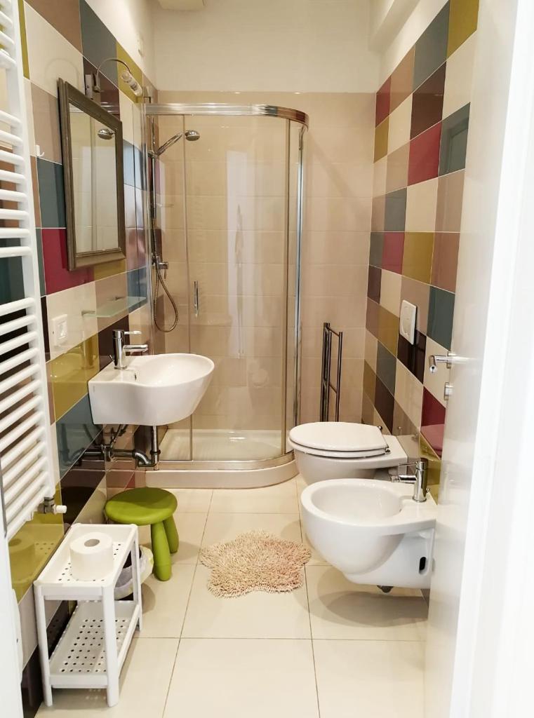 une salle de bain avec un lavabo, des toilettes et une douche dans l'établissement Margherita Rimini - Appartamenti al Mare, à Rimini