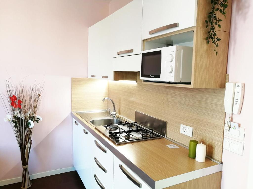 une cuisine avec un évier et une cuisinière four supérieur dans l'établissement Margherita Rimini - Appartamenti al Mare, à Rimini