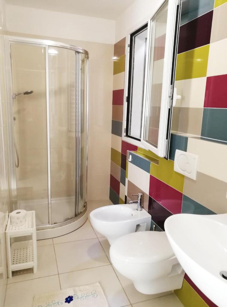 une salle de bain avec une douche, des toilettes et un lavabo dans l'établissement Margherita Rimini - Appartamenti al Mare, à Rimini 87 autres photos