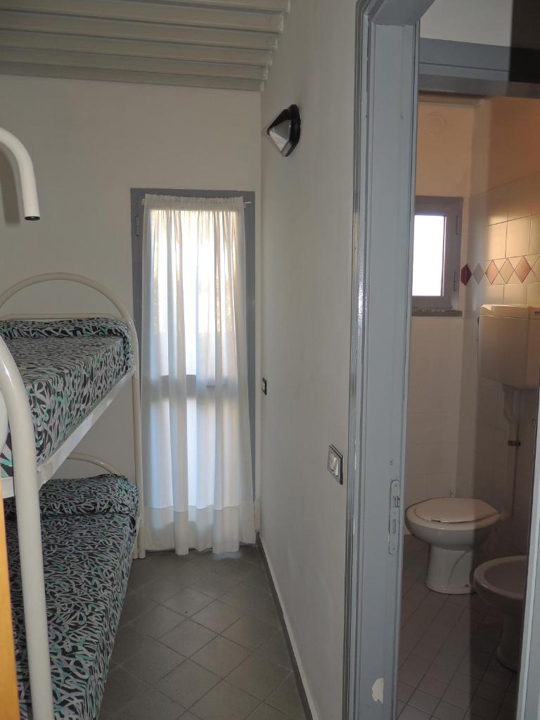 une salle de bain avec un lit superposé et des toilettes dans l'établissement Appartamenti Villaggio Internazionale, à Albenga