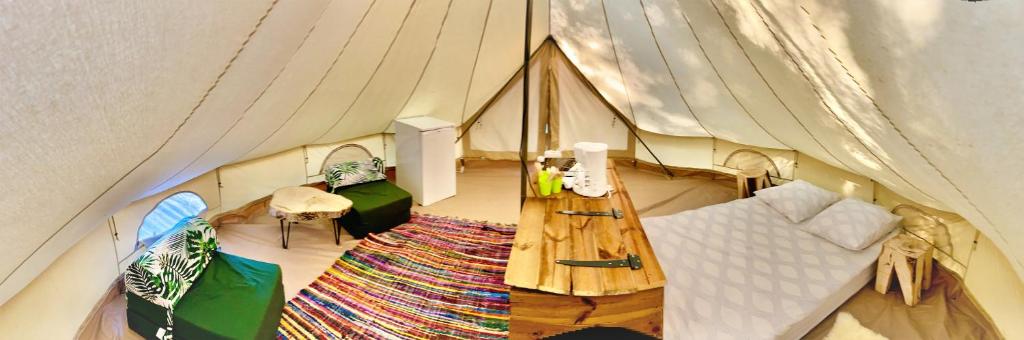 une chambre avec une tente dotée d'un canapé et d'un tapis dans l'établissement LES BASTIDES DE CHANTERAINE Bungalows, Lodges & Spa, à Aiguines