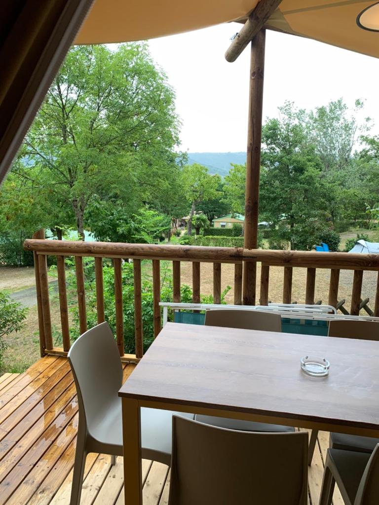- une terrasse couverte avec une table et des chaises dans l'établissement Camping Calme et Nature Iserand, à Vion