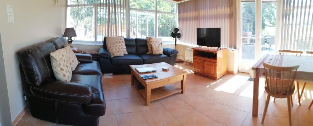 un salon avec un canapé et une table dans l'établissement Le Jarrier Gite - Alpes Mancelles, à Saint-Georges-le-Gaultier