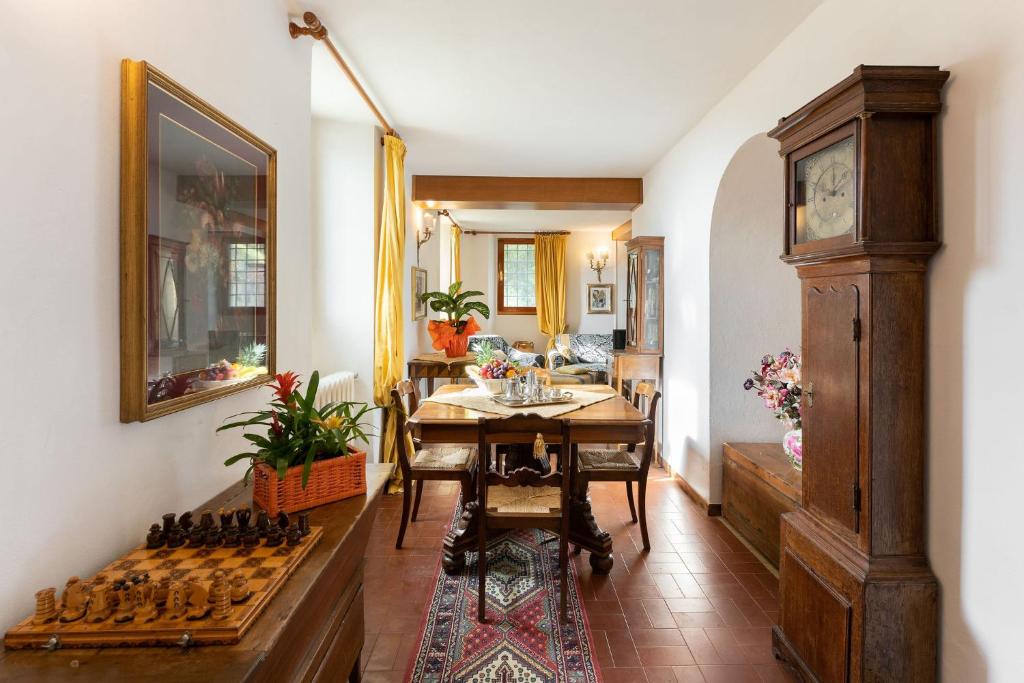une salle à manger avec une table et une horloge dans une pièce dans l'établissement Villa Mario, piscina privata,aria cond,immersa nel verde,campagna Toscana, à Pistoia