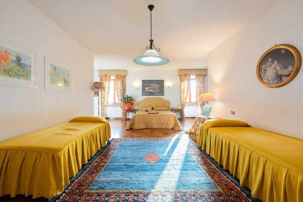Cette chambre comprend deux lits et un canapé. dans l'établissement Villa Mario, piscina privata,aria cond,immersa nel verde,campagna Toscana, à Pistoia