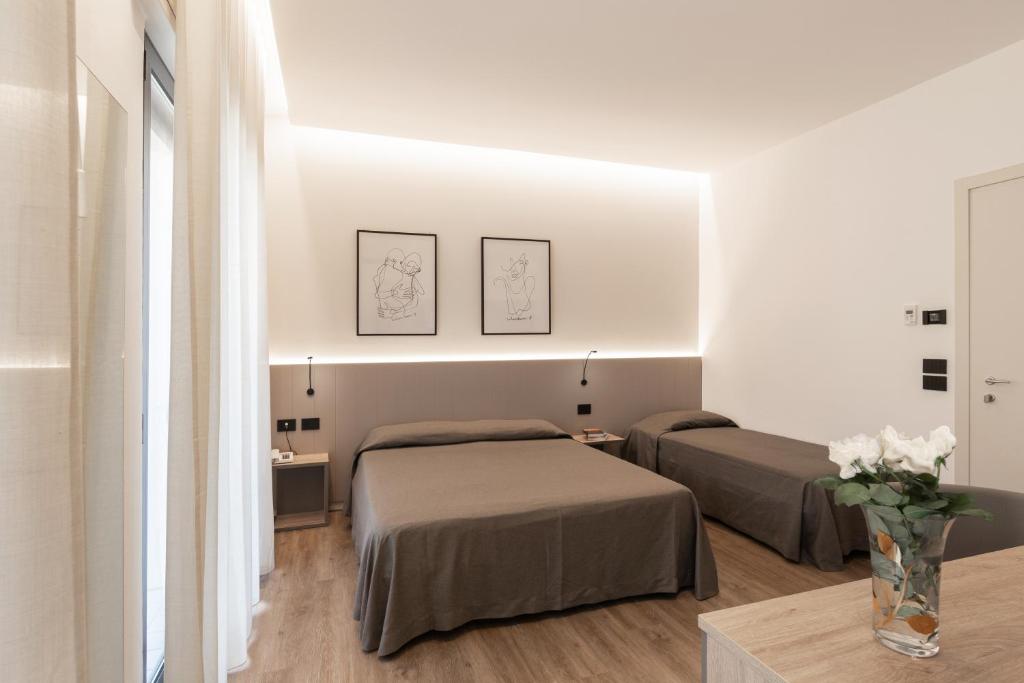 - une chambre avec 2 lits et un vase de fleurs dans l'établissement Renzo Hotel, à Cesenatico 33 autres photos