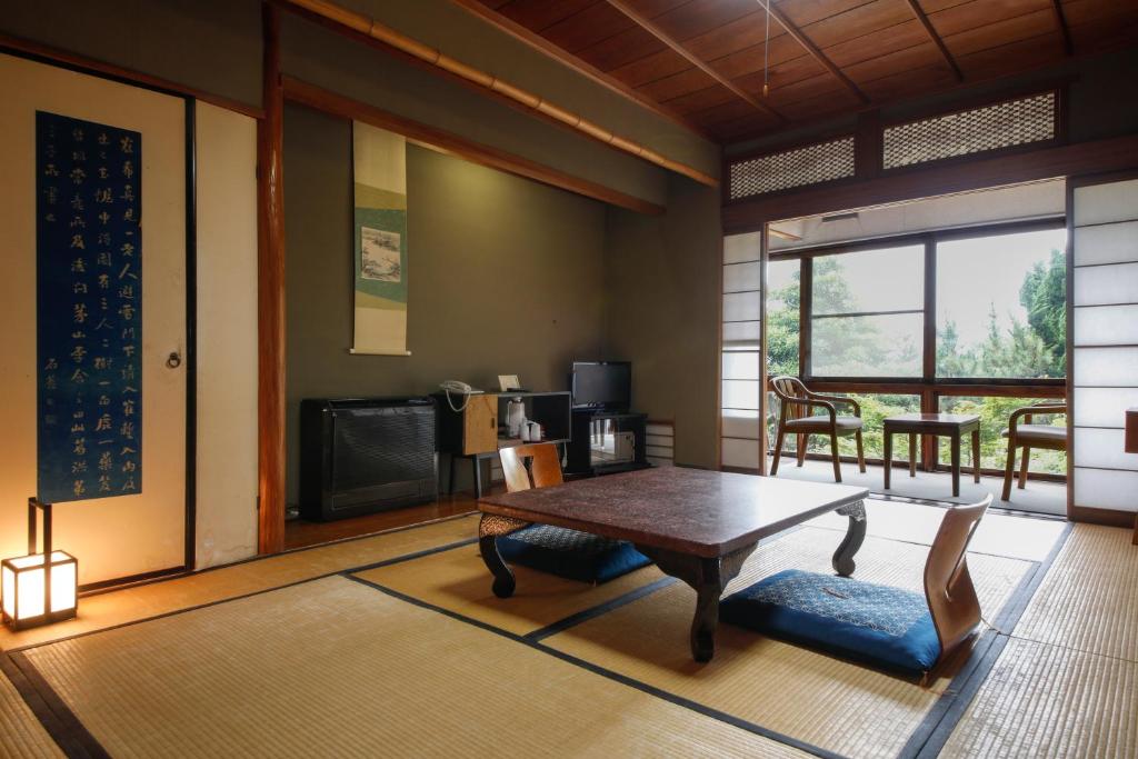 d'un salon avec une table et d'une chambre avec un balcon. dans l'établissement Seikiro Ryokan Historical Museum Hotel, à Miyazu