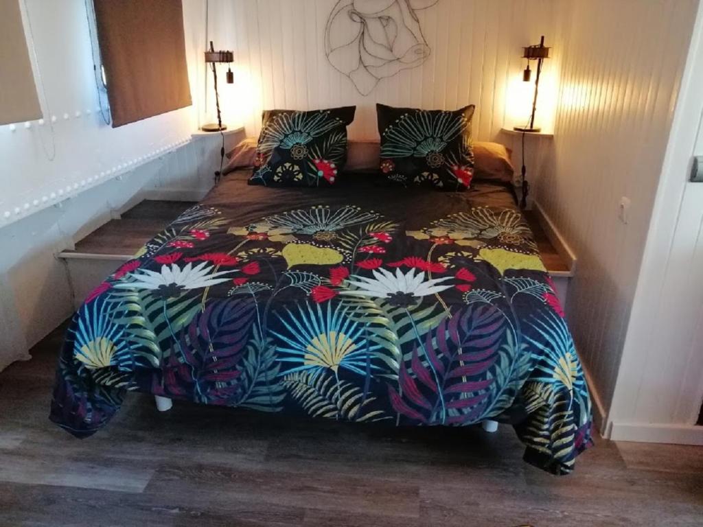 une chambre avec un lit avec une couette colorée dans l'établissement Séjour atypique et insolite sur notre péniche La Coradine avec grand spa, à Aigues-Mortes