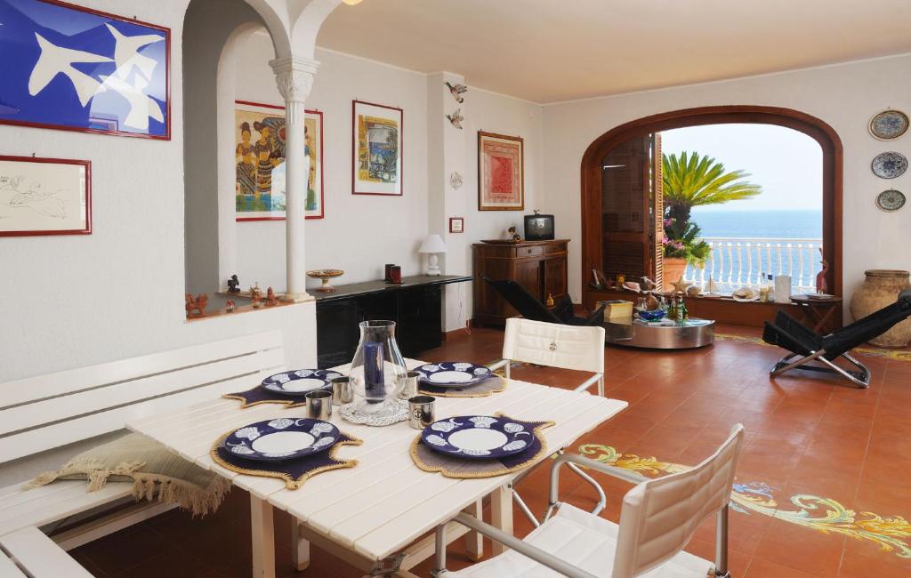 une salle à manger avec une table et une vue sur l'océan dans l'établissement Villa Azzurra, à Conca dei Marini
