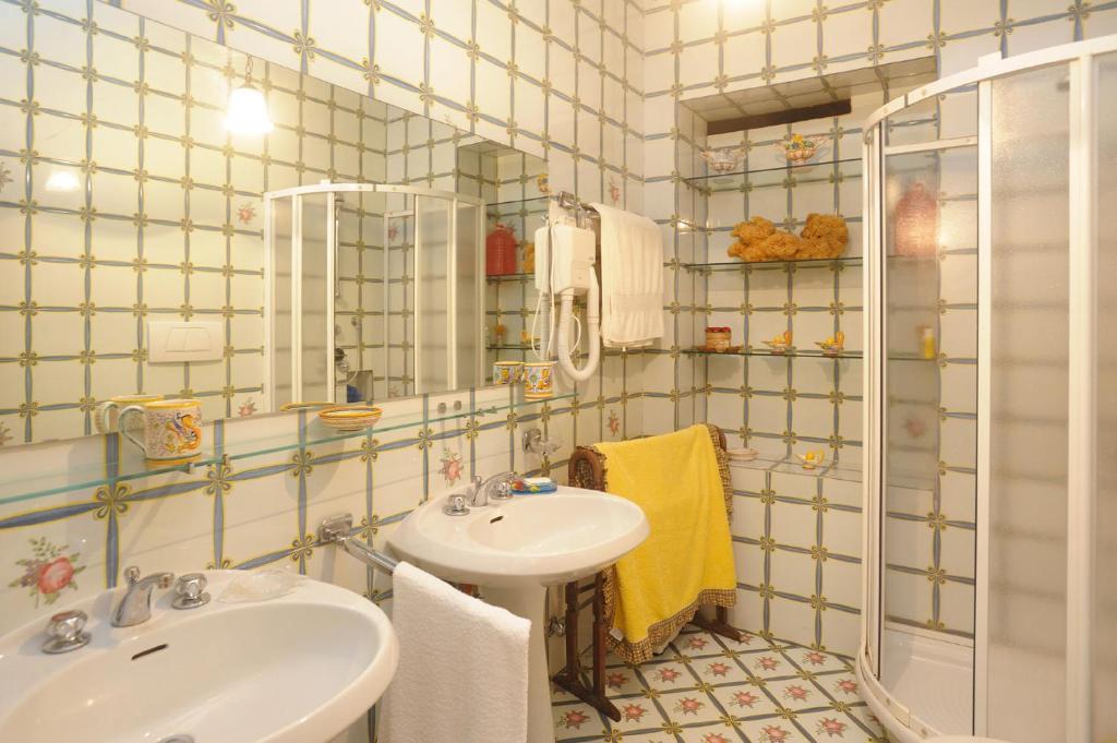 une salle de bain avec un lavabo et un miroir dans l'établissement Villa Azzurra, à Conca dei Marini