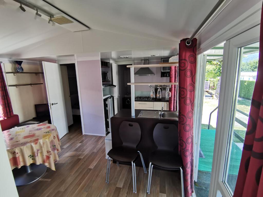une cuisine et une salle à manger avec une table et des chaises dans l'établissement CAMPING LE GRAND VERNEY, à Novalaise 1 autre photo