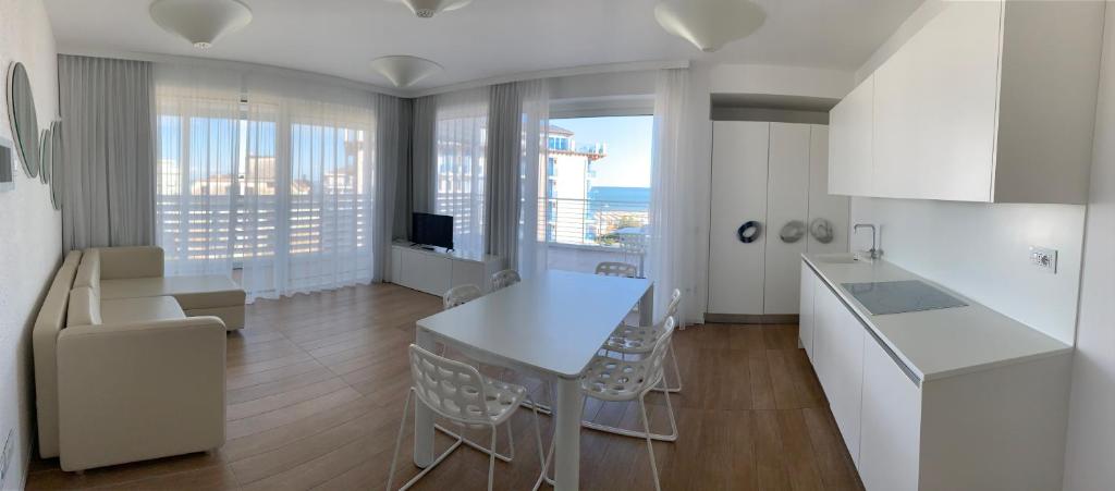 une cuisine avec une table et des chaises dans une pièce dans l'établissement Marina Verde Resort Official, à Caorle