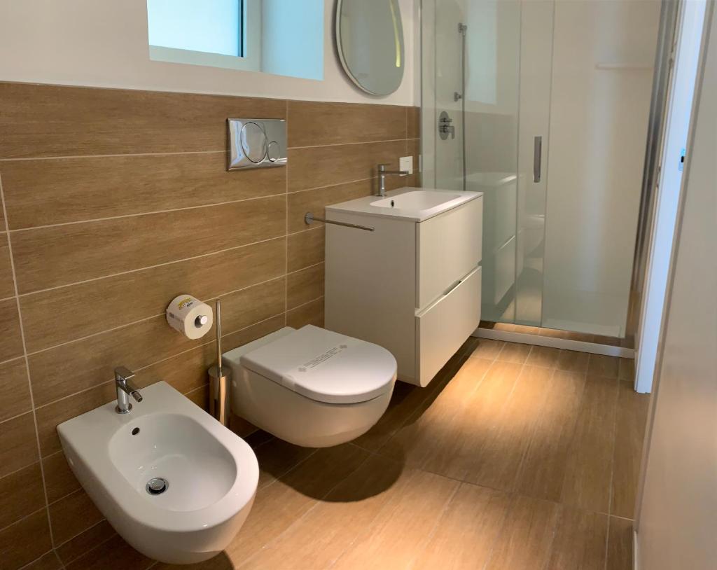 une salle de bain avec toilettes, lavabo et miroir dans l'établissement Marina Verde Resort Official, à Caorle