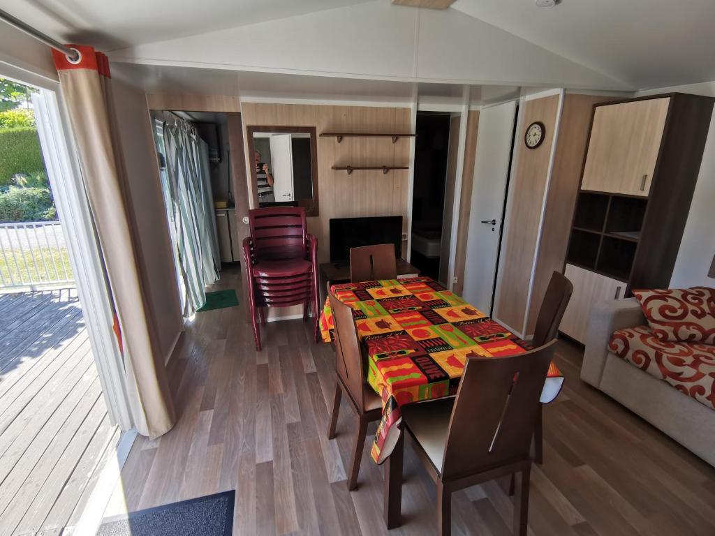 une chambre avec une table et des chaises ainsi qu'un salon dans l'établissement CAMPING LE GRAND VERNEY, à Novalaise