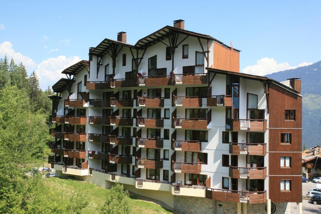 un bâtiment avec balcon sur le côté d'une colline dans l'établissement Résidence Saboia B13 Clés Blanches Courchevel, à Courchevel