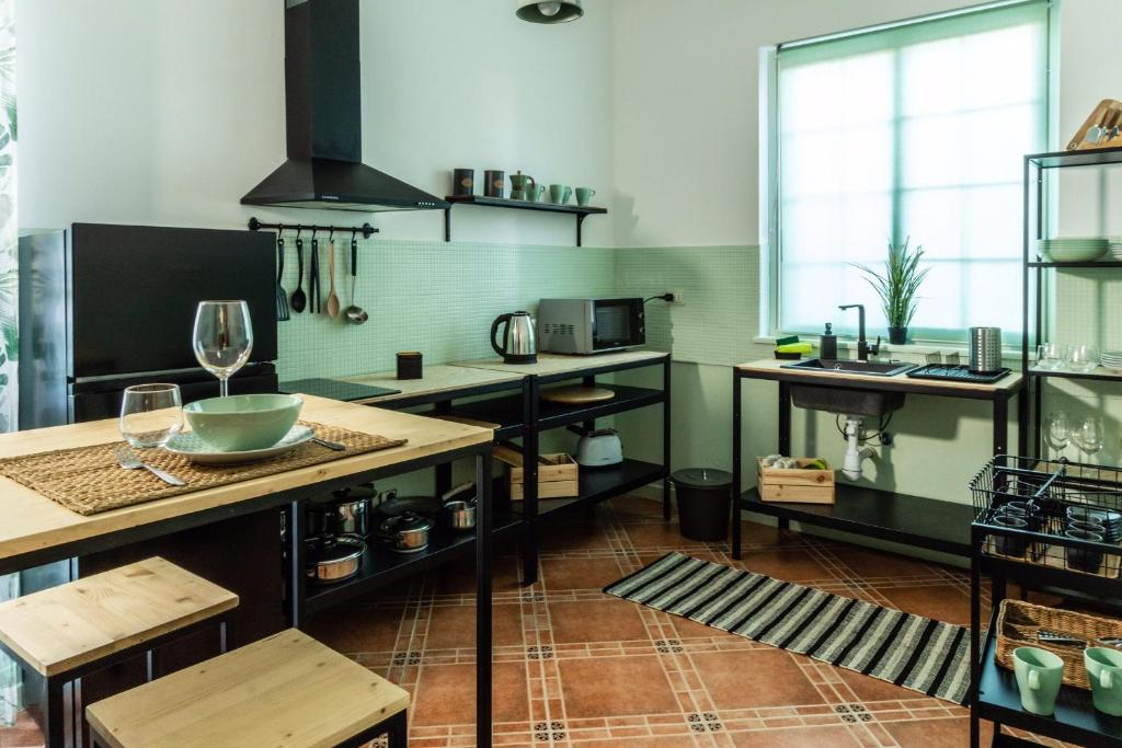 - une cuisine avec des murs verts et des comptoirs en bois dans l'établissement Villa Bienvenue, à Carini