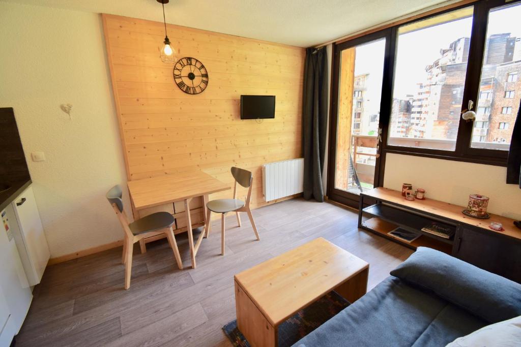 un salon avec une table et une horloge murale dans l'établissement STUDIO CABINE COSY TRÈS CALME RÉSIDENCE ALPAGES 2 AU PIED DES PISTES, à Avoriaz