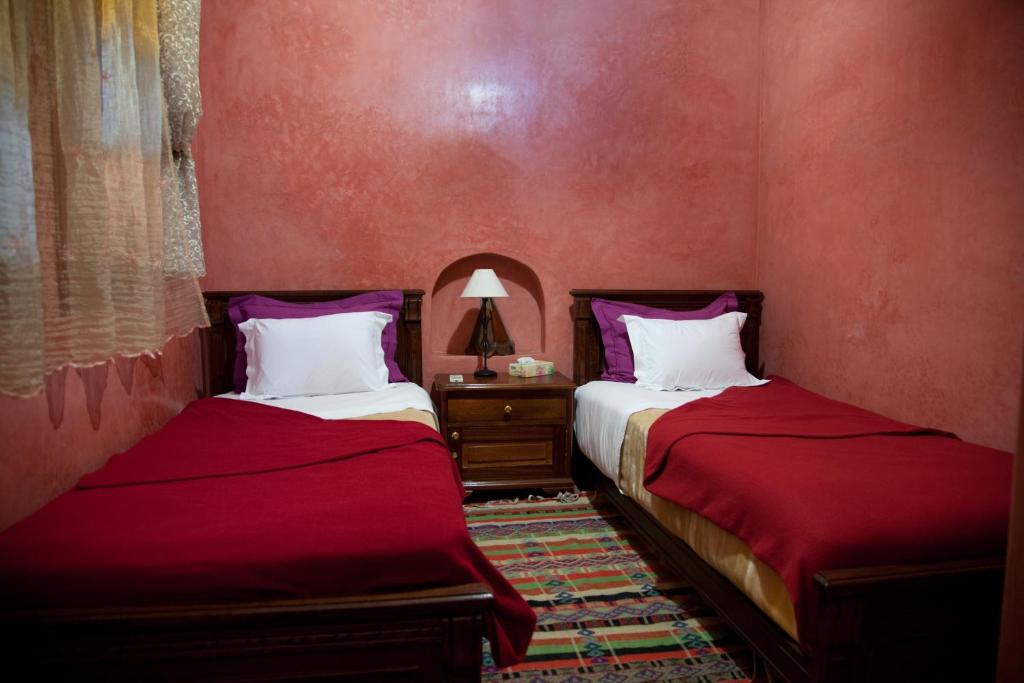 - 2 lits dans une chambre aux murs rouges dans l'établissement Riad Dar Alia, à Rabat 20 autres photos