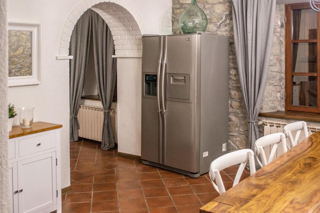 une cuisine avec un réfrigérateur en acier inoxydable dans une pièce dans l'établissement MULINO VECCHIO, à Minucciano