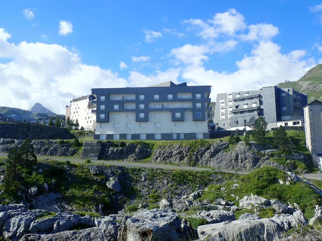 un bâtiment au sommet d'une montagne avec des rochers dans l'établissement Appartements du Pic d'Anie, à Arette