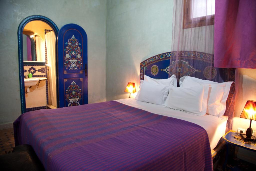 - une chambre dotée d'un lit avec un couvre-lit violet et bleu dans l'établissement Riad Dar Alia, à Rabat
