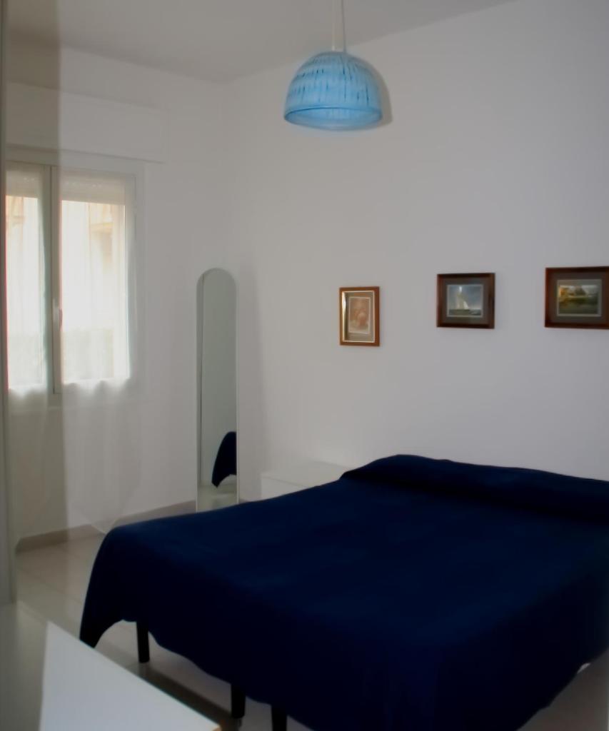 une chambre avec un lit bleu et une lumière dans l'établissement Residenza Abbo, à Diano Marina