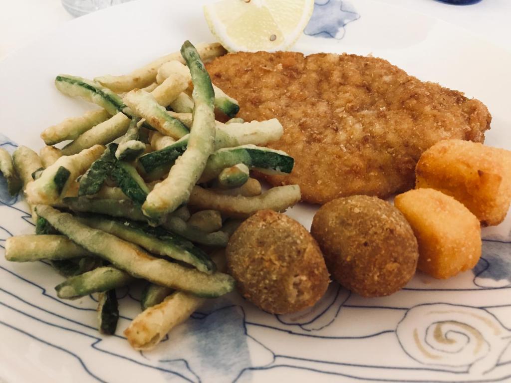 une assiette de nourriture avec de la viande frite et des frites dans l'établissement Hotel Bahia, à San Benedetto del Tronto 75 autres photos