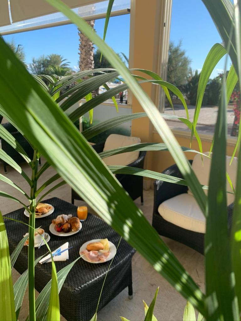 deux plaques alimentaires sur une table avec des plantes dans l'établissement Hotel Bahia, à San Benedetto del Tronto