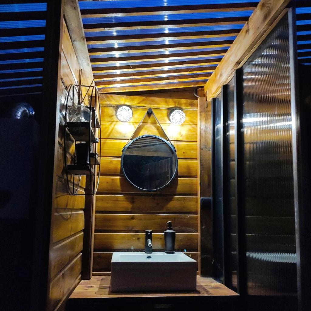 une salle de bain avec un lavabo et un miroir dans l'établissement Le Wigwam du Fassac, à Saint-Julien-du-Puy 37 autres photos