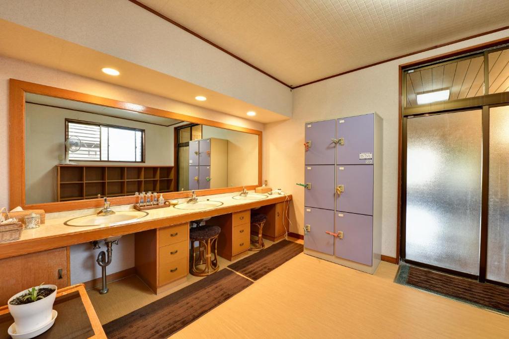 une salle de bain avec deux lavabos et un grand miroir dans l'établissement Rakusuien, à Kōfu