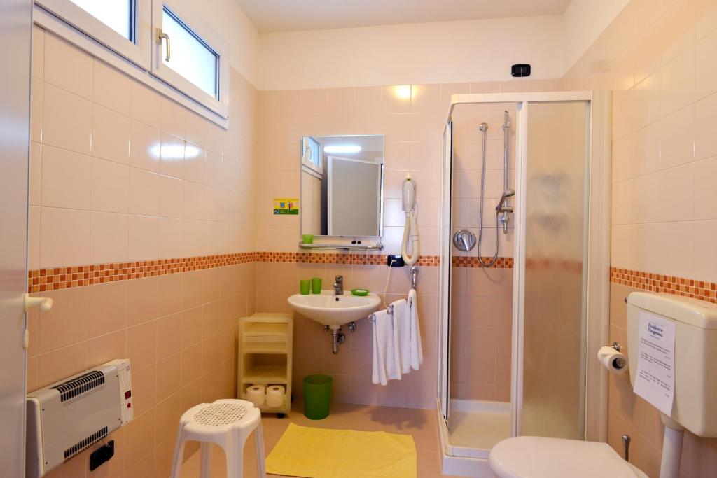 une salle de bain avec douche, lavabo et toilettes dans l'établissement Hotel & Residence Progresso, à Lido di Jesolo