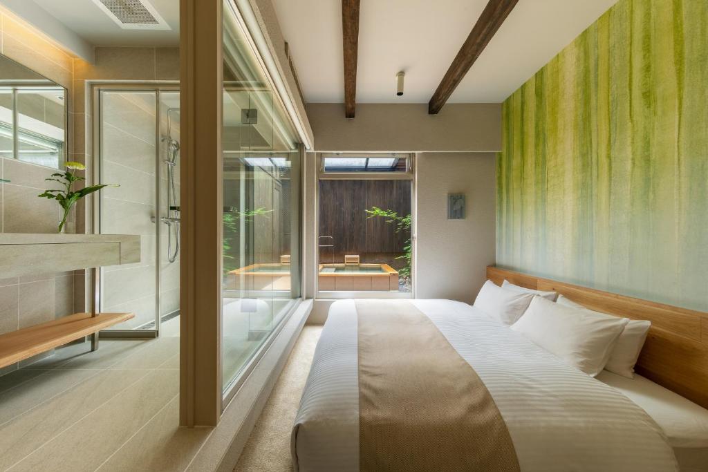 une chambre avec un lit et une paroi vitrée dans l'établissement Nazuna Kyoto Tsubaki St., à Kyoto