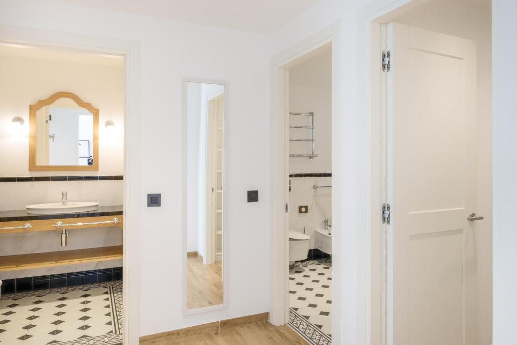 une salle de bain avec toilettes, lavabo et miroir dans l'établissement Hapimag Apartments Cavallino, à Cavallino-Treporti