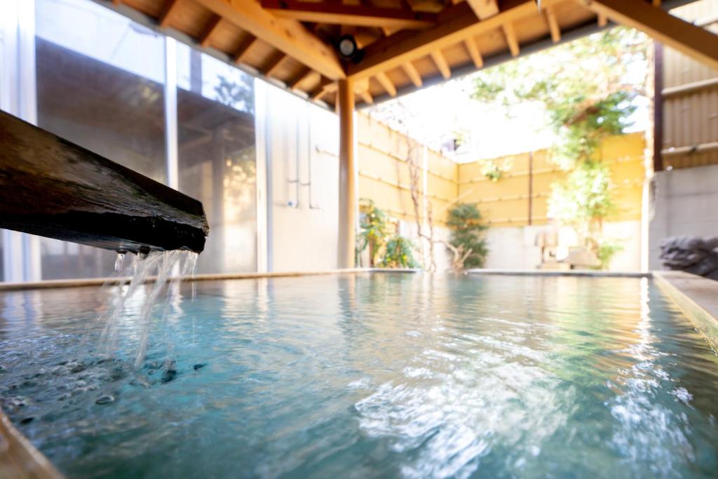 une piscine avec de l'eau provenant d'une fontaine dans l'établissement Suwakoen, à Suwa