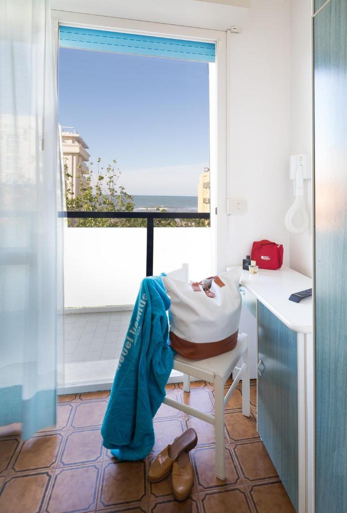 une pièce avec une table et un bureau avec une fenêtre dans l'établissement Hotel Taunus - Vista Mare, à Riccione