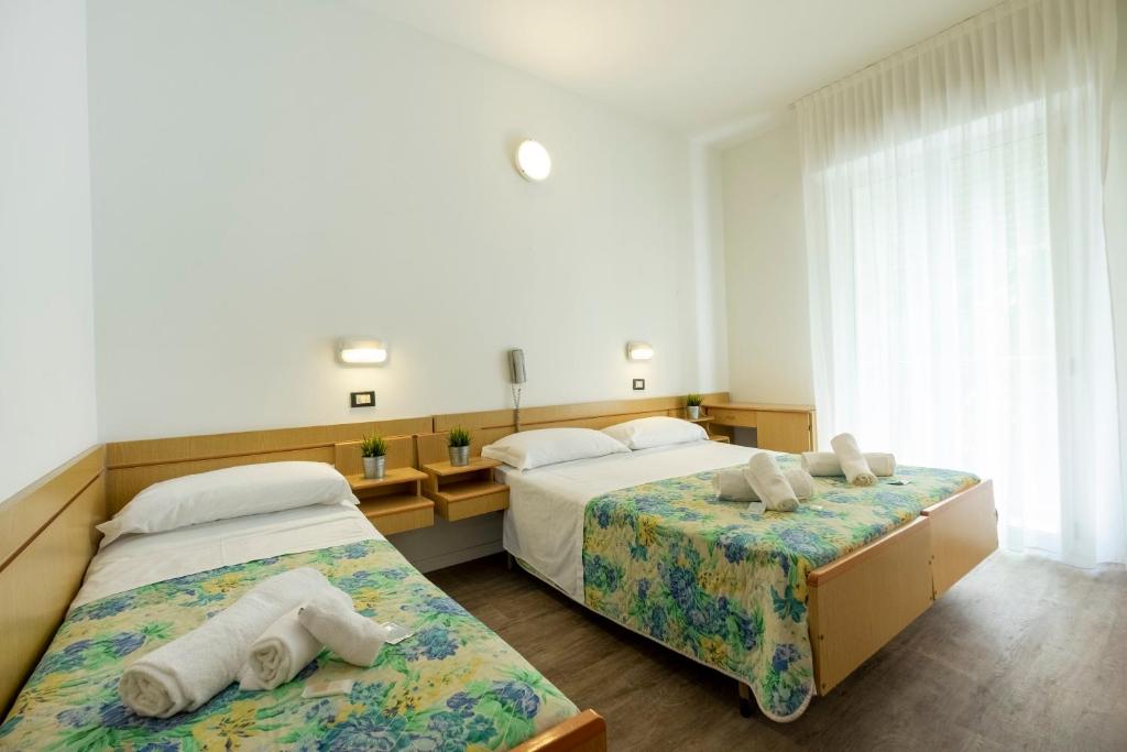 deux lits dans une chambre d'hôtel avec des serviettes dessus dans l'établissement Hotel Lexington, à Rimini