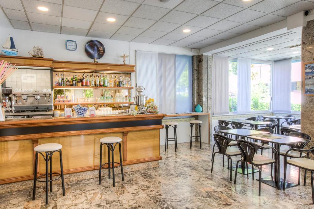 un bar avec des tables et des chaises dans un restaurant dans l'établissement Hotel Taunus - Vista Mare, à Riccione
