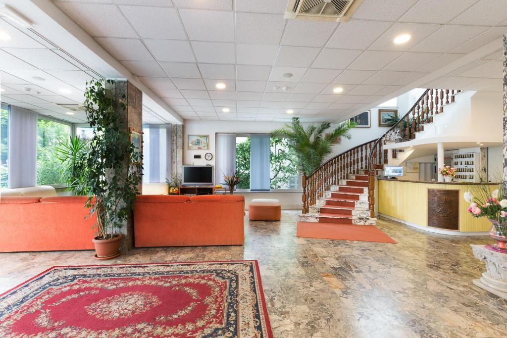 un hall de bureau avec un escalier et un tapis dans l'établissement Hotel Taunus - Vista Mare, à Riccione
