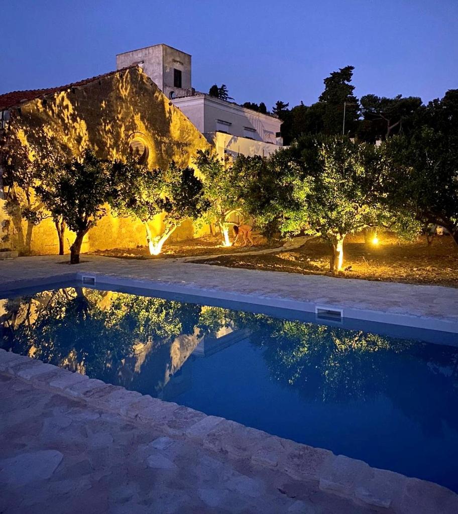 une piscine avec des arbres et un bâtiment en arrière-plan dans l'établissement Masseria Villa Gioia, à Corato 59 autres photos