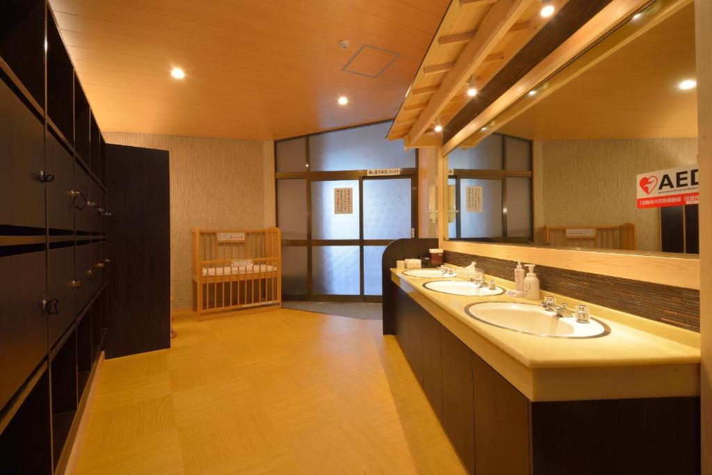 une salle de bain avec deux lavabos et un grand miroir dans l'établissement Hakone Kowakien Mikawaya Ryokan, à Hakone