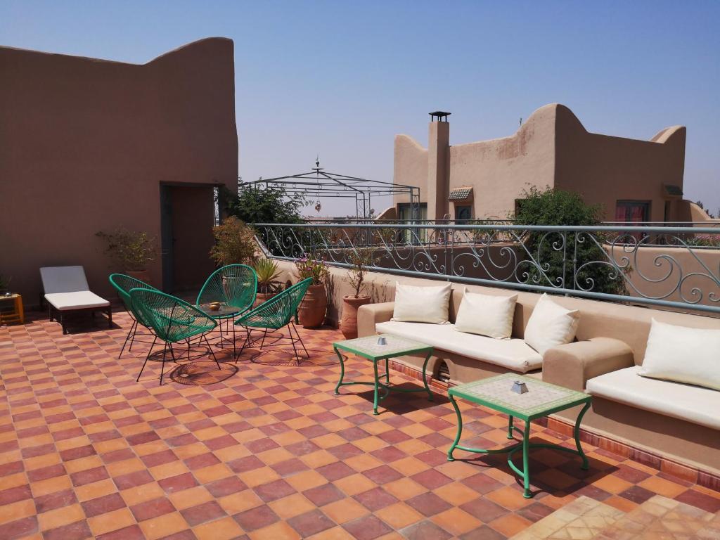 d'une terrasse avec des chaises et des canapés sur un balcon. dans l'établissement Riad Ain Khadra, à Taroudant