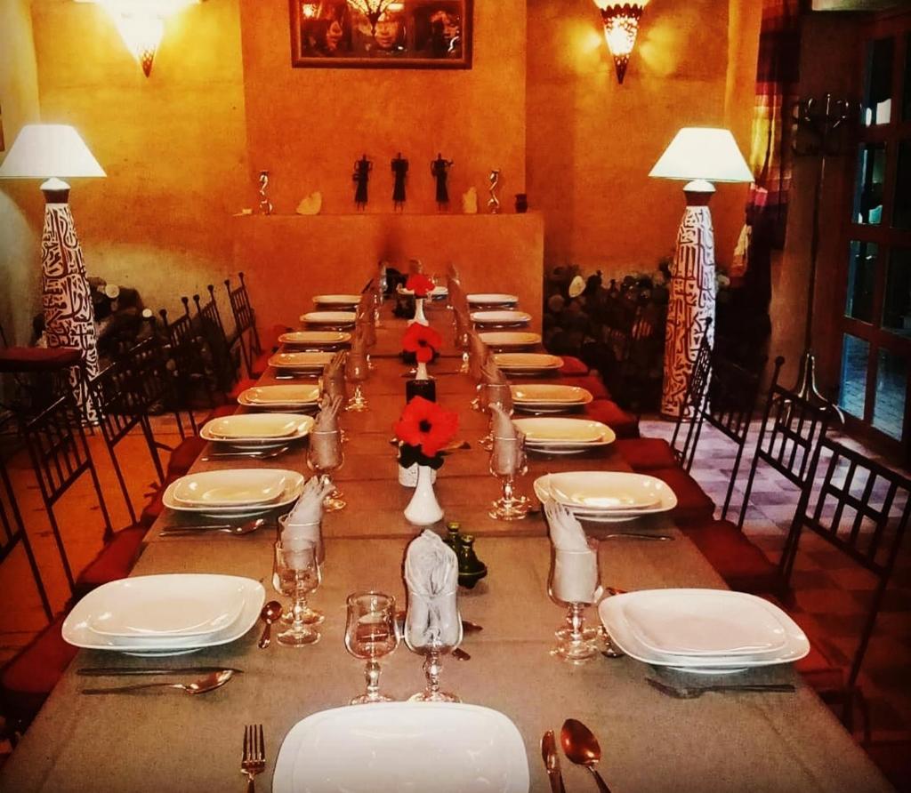 - une grande table avec des assiettes et des verres blancs dans l'établissement Riad Ain Khadra, à Taroudant